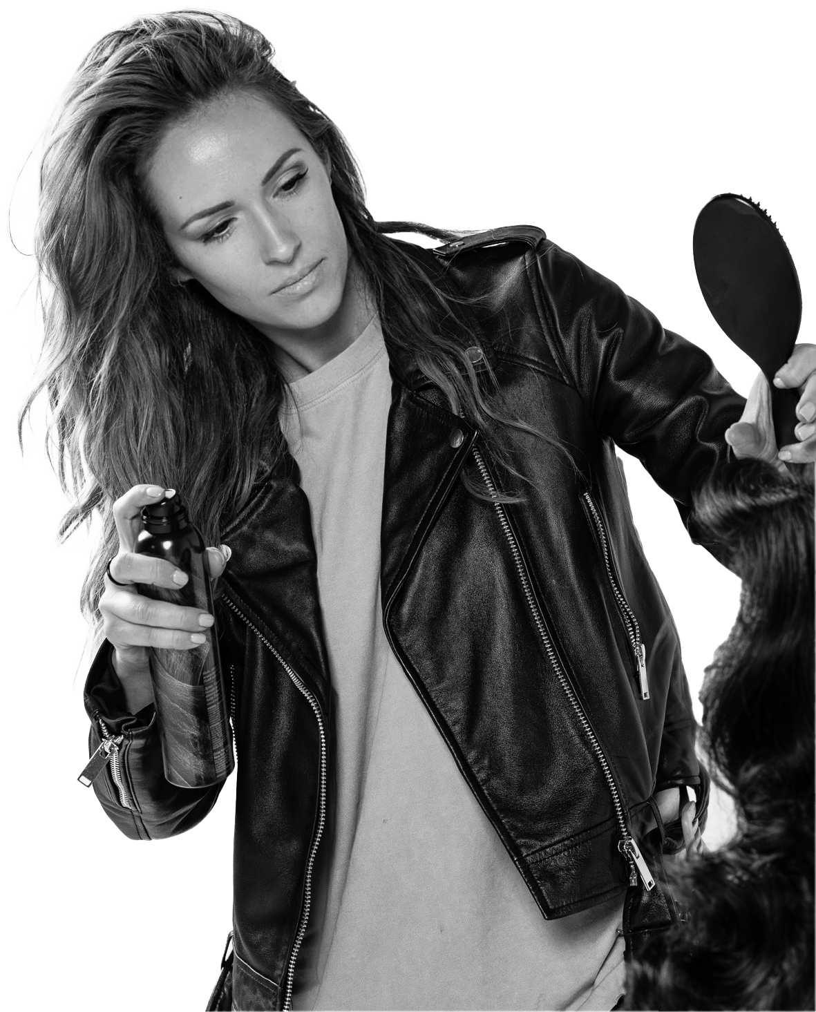 Black and white portrait of a hairdresser in a leather jacket applying fixing spray of the model's hair