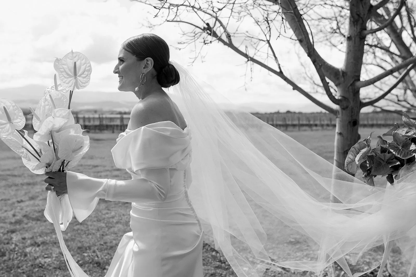 Bride in elegant dress holding bouquet of lilies on her wedding day