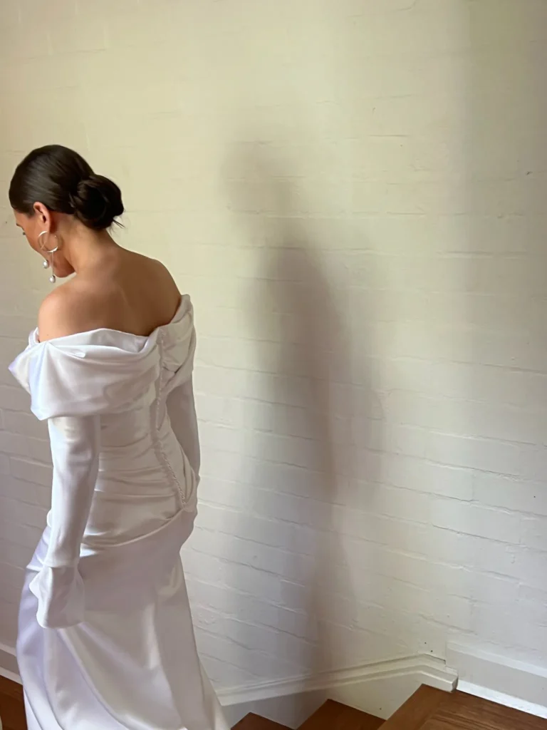 Bride going down stairs in front of a beige wall